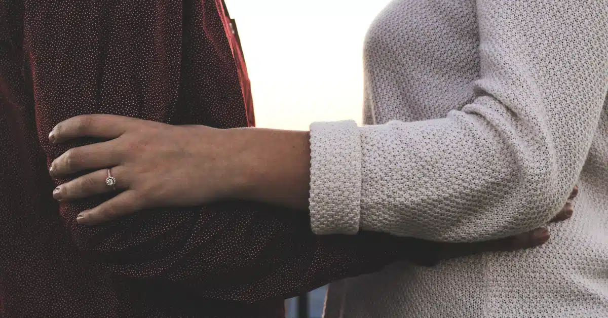 person in gray sweater holding black and red textile