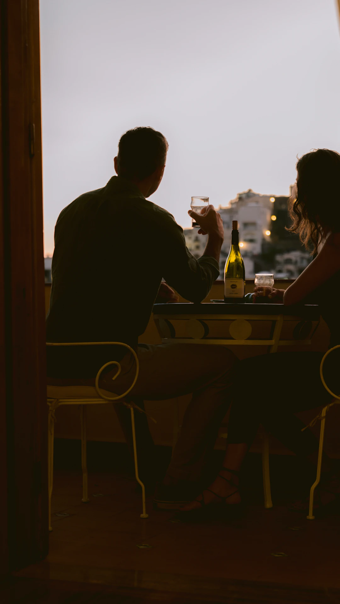 man and woman sitting on chair in front of table during sunset