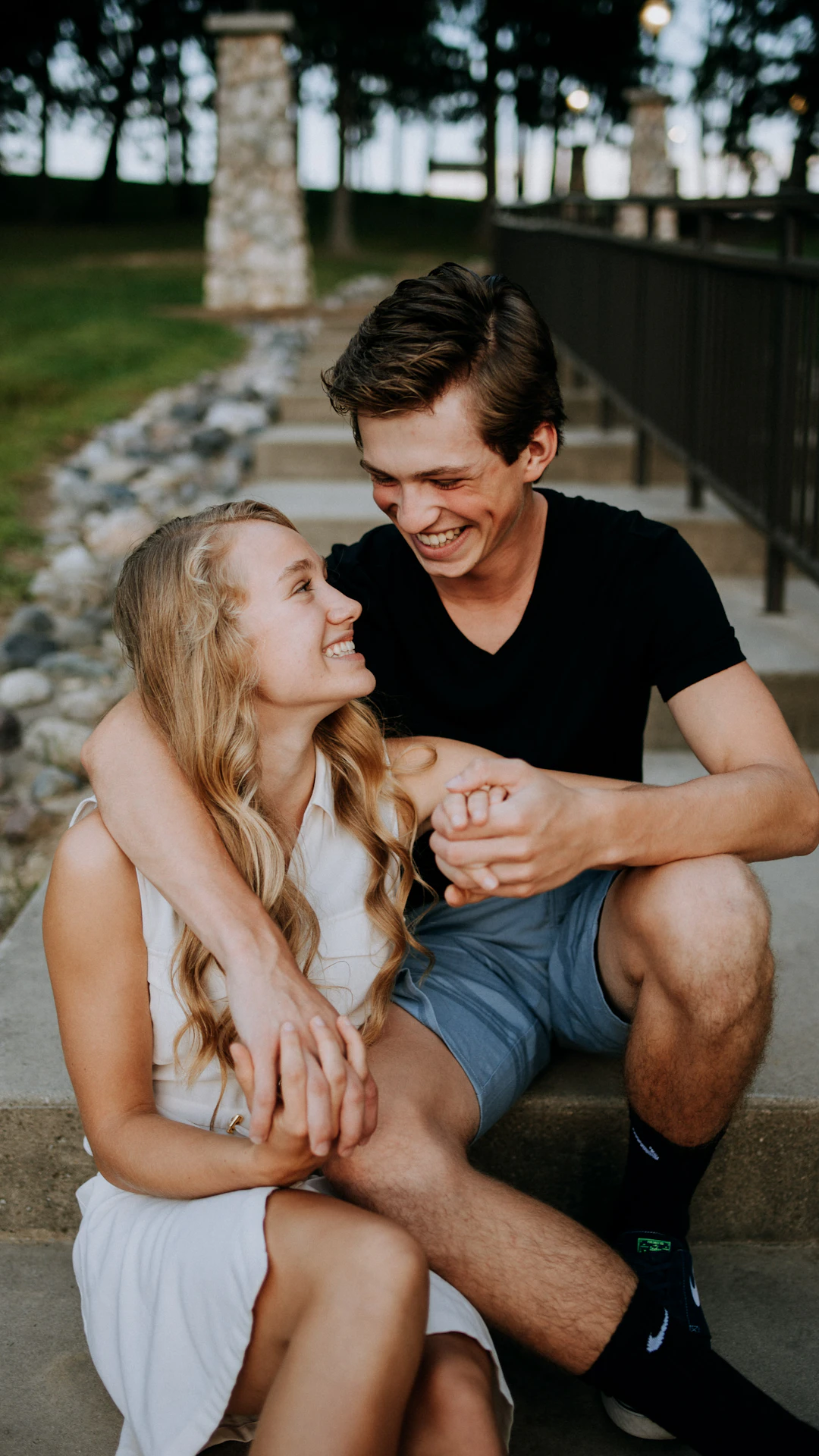 man holding the hand of a woman while siting on concrete staircase